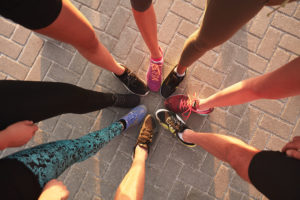 women showing off their running shoes